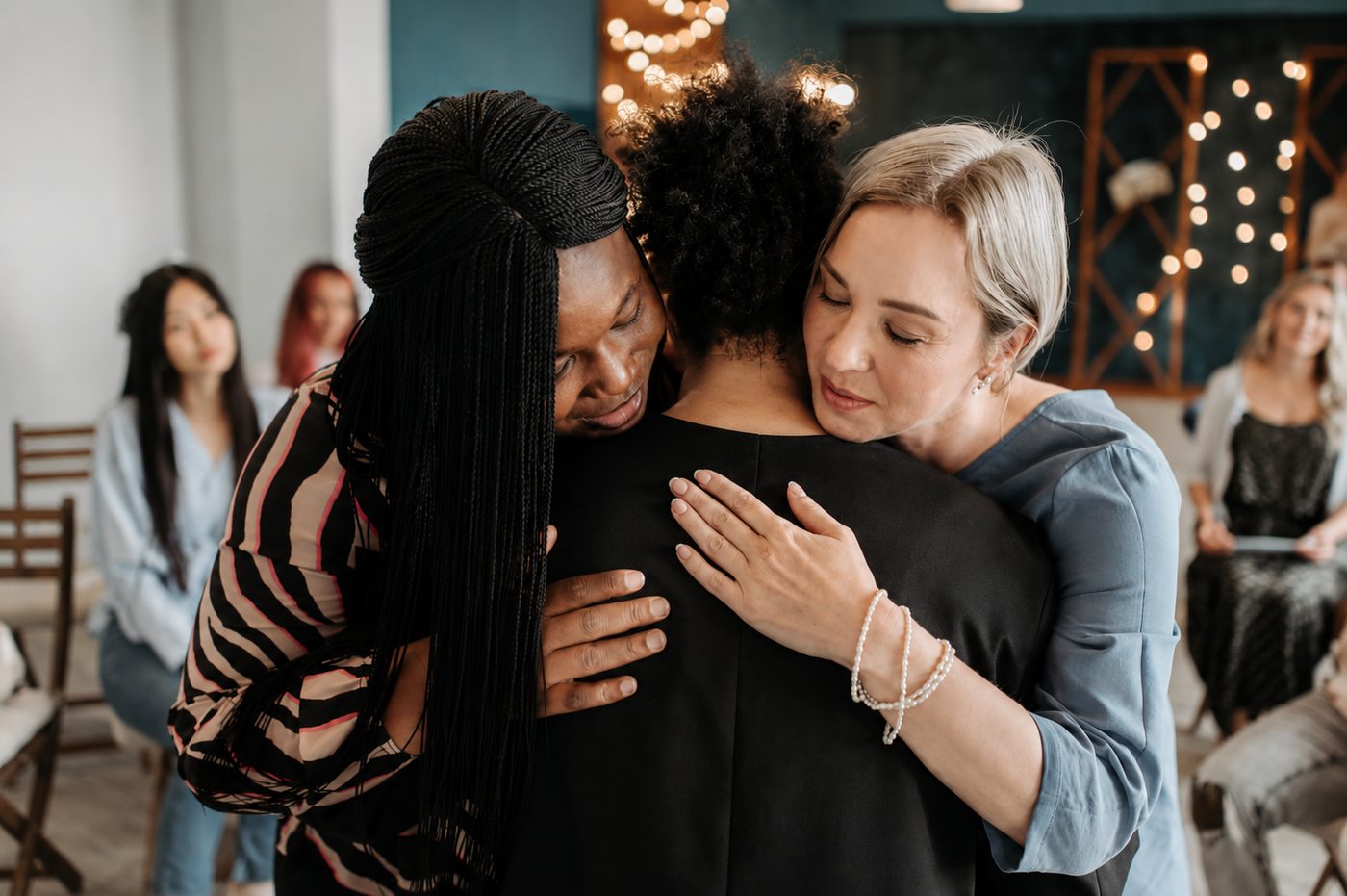 Trois femmes s'embrassant chaleureusement lors d'une rencontre